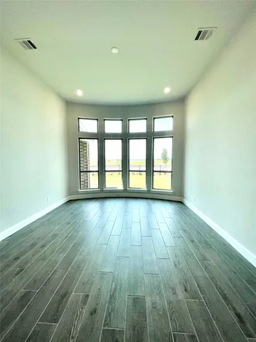 an empty room with windows and fireplace