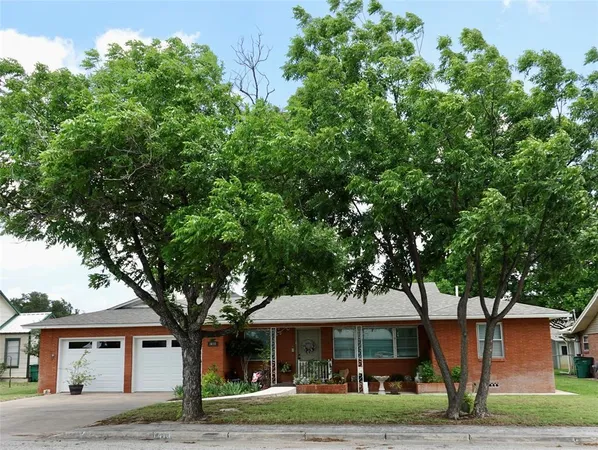 a front view of a house with trees and trees