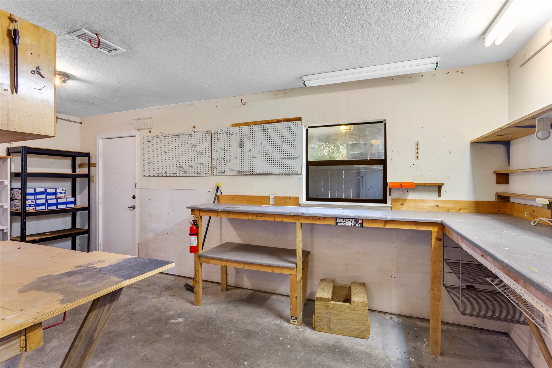67 Harbor Lane Kemah, TX 77565 - Photo 39 of 47 In addition to the two car garage, there is also a functional garage workshop with ample counter space, pegboards for tool organization, open shelving, and a window for natural light. Ideal for DIY projects and storage.