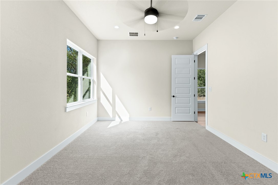 223 Allen Street Bartlett, TX 76511 - Photo 15 of 21 an empty room with a windows and chandelier fan