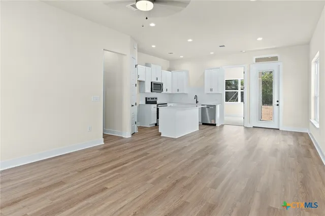 an open kitchen with white cabinets and stainless steel appliances
