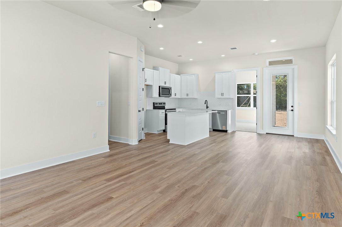 223 Allen Street Bartlett, TX 76511 - Photo 4 of 21 an open kitchen with white cabinets and stainless steel appliances