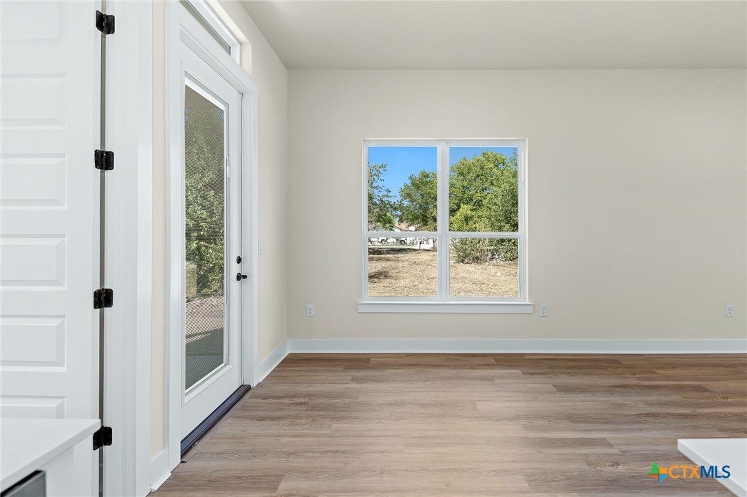 223 Allen Street Bartlett, TX 76511 - Photo 8 of 21 a view of an empty room with wooden floor and a window
