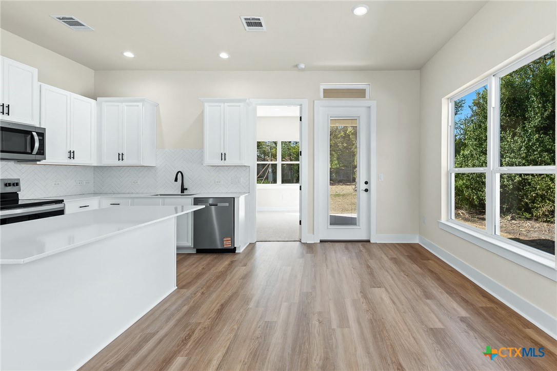223 Allen Street Bartlett, TX 76511 - Photo 10 of 21 a kitchen with wooden floors and white appliances