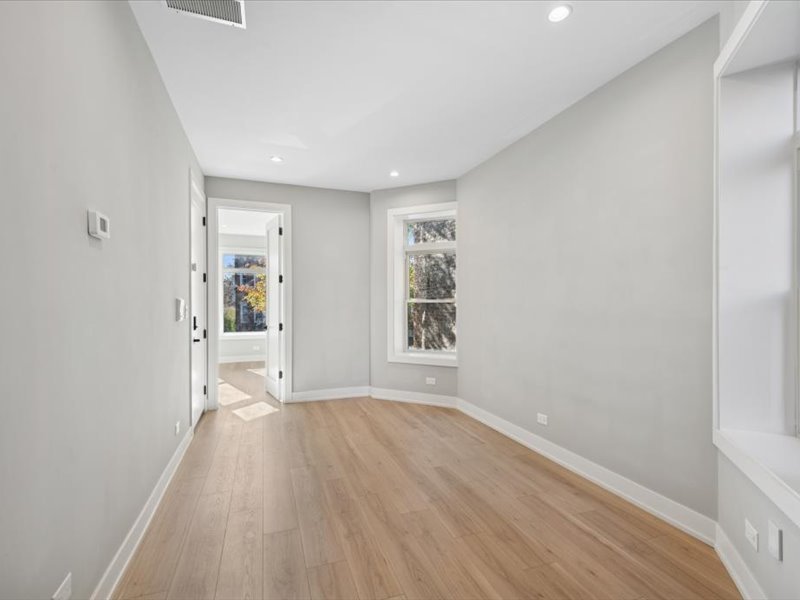 2818 West Fletcher Street, Unit 1 Chicago, IL 60618 - Photo 7 of 18 wooden floor in an empty room with a window