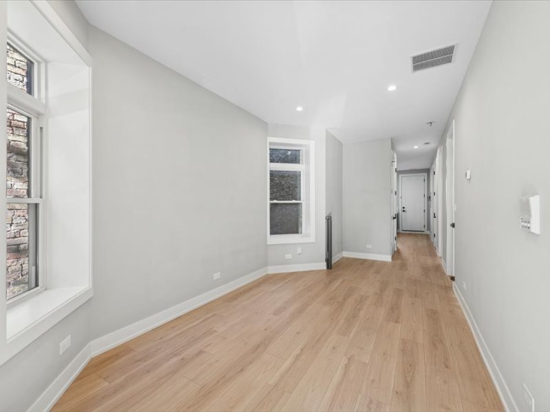 2818 West Fletcher Street, Unit 1 Chicago, IL 60618 - Photo 8 of 18 a view of empty room with wooden floor and fan