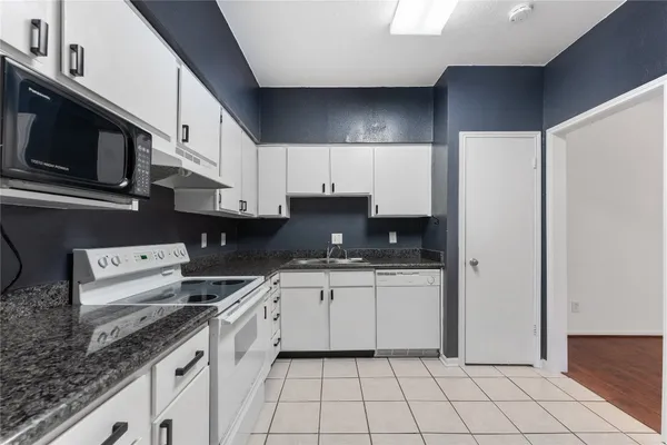 a kitchen with a sink a stove and cabinets