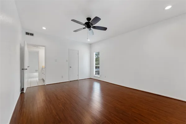 a view of an empty room with wooden floor