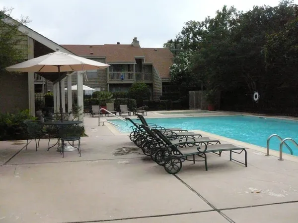 a view of a patio with a table and chairs under an umbrella