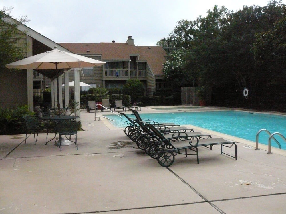 2100 Tanglewilde Street, Unit 330 Houston, TX 77063 - Photo 22 of 22 a view of a patio with a table and chairs under an umbrella
