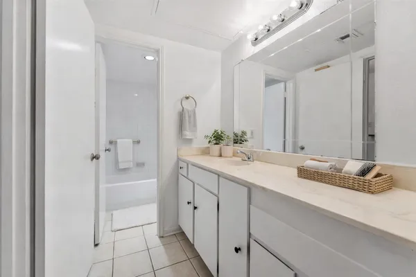 a bathroom with a double vanity sink mirror and bathtub