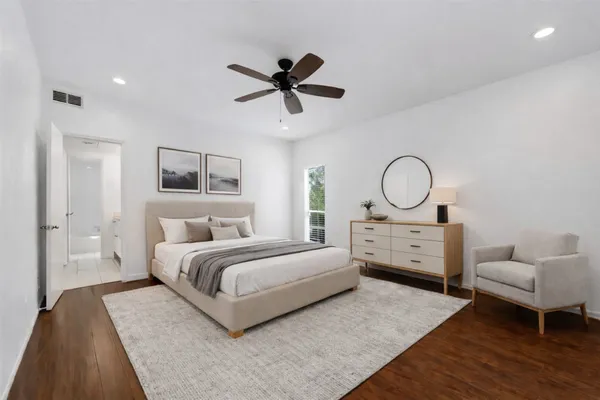 a bedroom with a large bed and wooden floor
