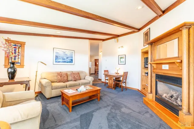 a living room with fireplace furniture and a large window