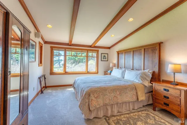 a spacious bedroom with a large bed and a large window