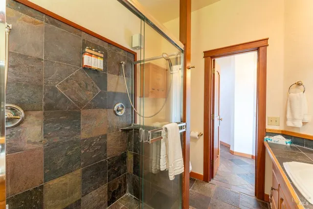 a open kitchen with stainless steel appliances granite countertop a stove top oven a sink a dining table and chairs with wooden floor