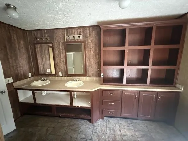 a room with table chairs and wooden cabinets