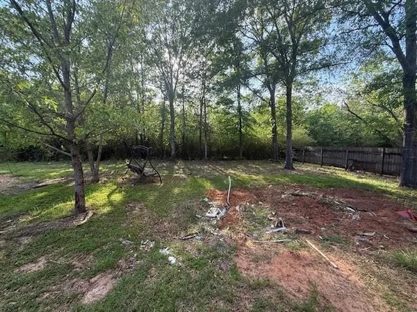 a backyard of a house with lots of plants and tree