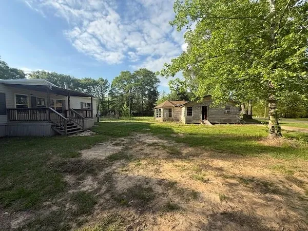 a view of house with backyard and tree