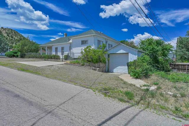 a view of a house with a yard and potted plants