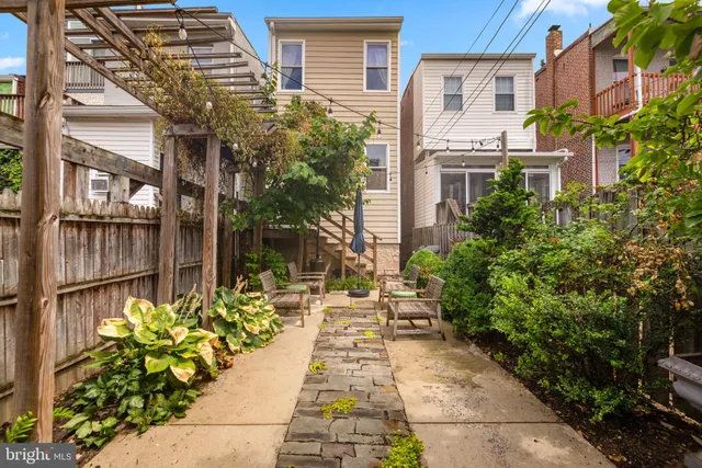 a view of a chair and tables in the back yard of the house