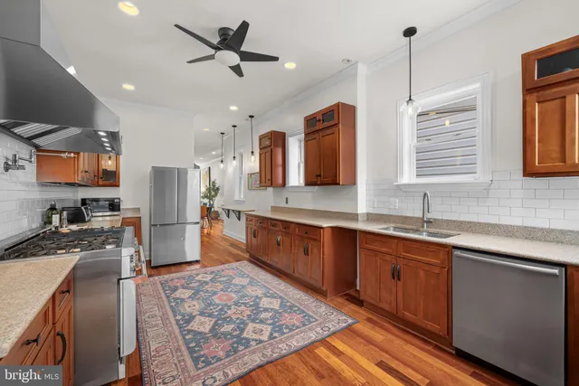 a large kitchen with stainless steel appliances granite countertop a sink stove and refrigerator