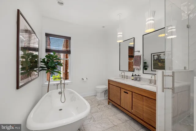 a bathroom with a sink a toilet and a large mirror