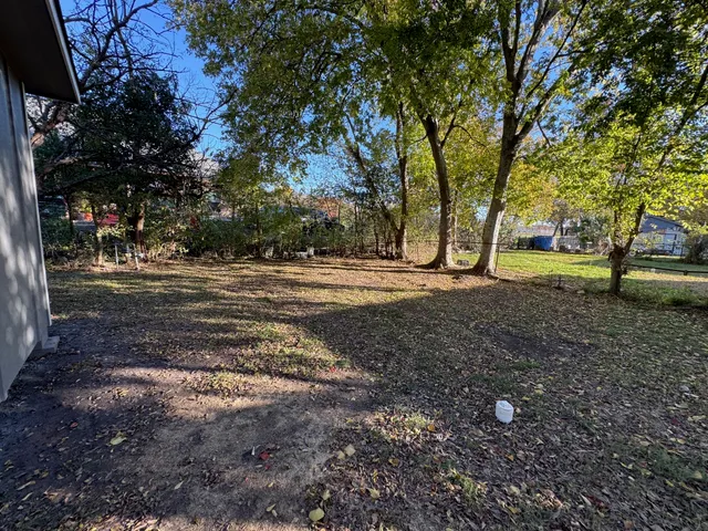 a view of a yard with large trees