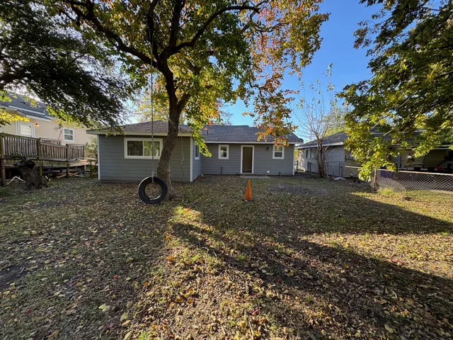 a view of a yard with a house and a large tree
