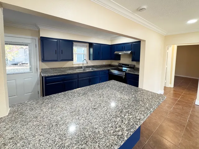 a kitchen with stainless steel appliances granite countertop a stove sink and cabinets