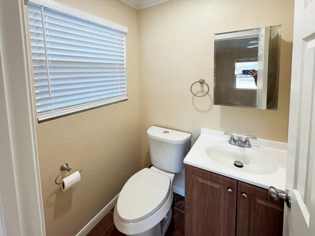 a bathroom with a toilet a sink and mirror