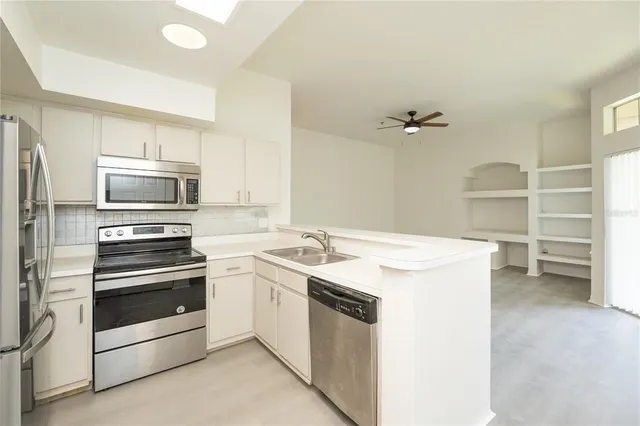 a view of a kitchen with a stove top oven and cabinets