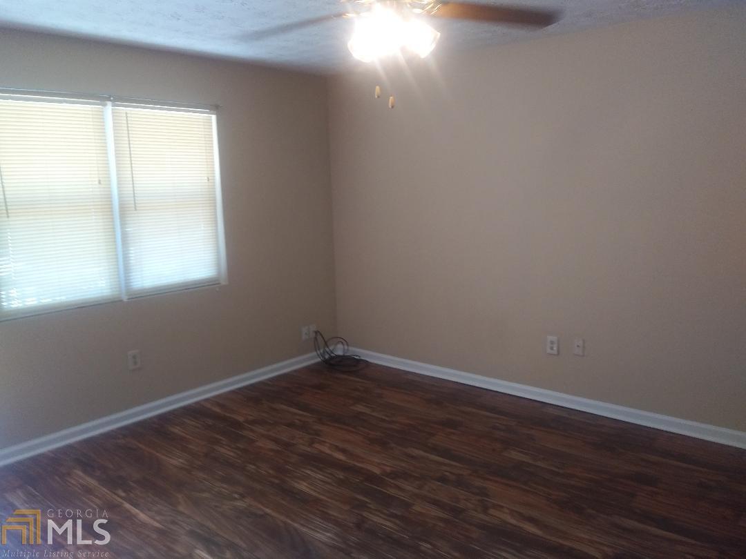 82 Paris Circle, Unit A Hiram, GA 30141 - Photo 8 of 12 an empty room with wooden floor and windows