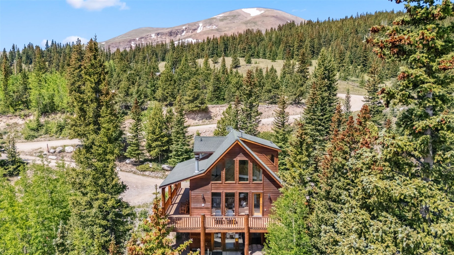 Rear view of house with a forest view and a mountain view