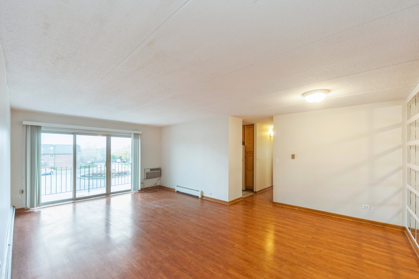 577 Fairway View Drive, Unit 2L Wheeling, IL 60090 - Photo 2 of 15 a view of an empty room with wooden floor and a window