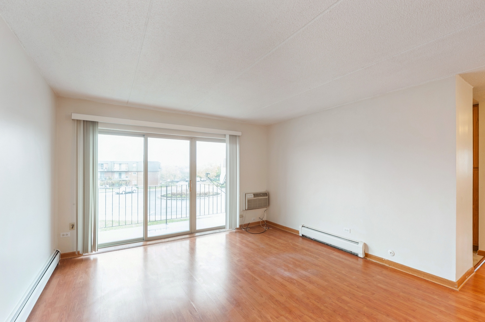 577 Fairway View Drive, Unit 2L Wheeling, IL 60090 - Photo 3 of 15 a view of an empty room with wooden floor and a window
