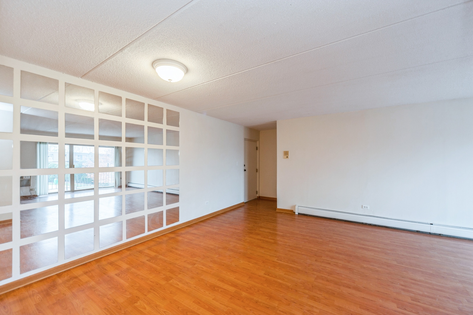 577 Fairway View Drive, Unit 2L Wheeling, IL 60090 - Photo 6 of 15 an empty room with wooden floor and windows