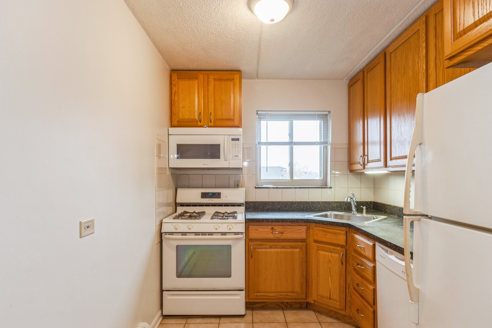577 Fairway View Drive, Unit 2L Wheeling, IL 60090 - Photo 7 of 15 a kitchen with stainless steel appliances granite countertop a sink a stove and a microwave