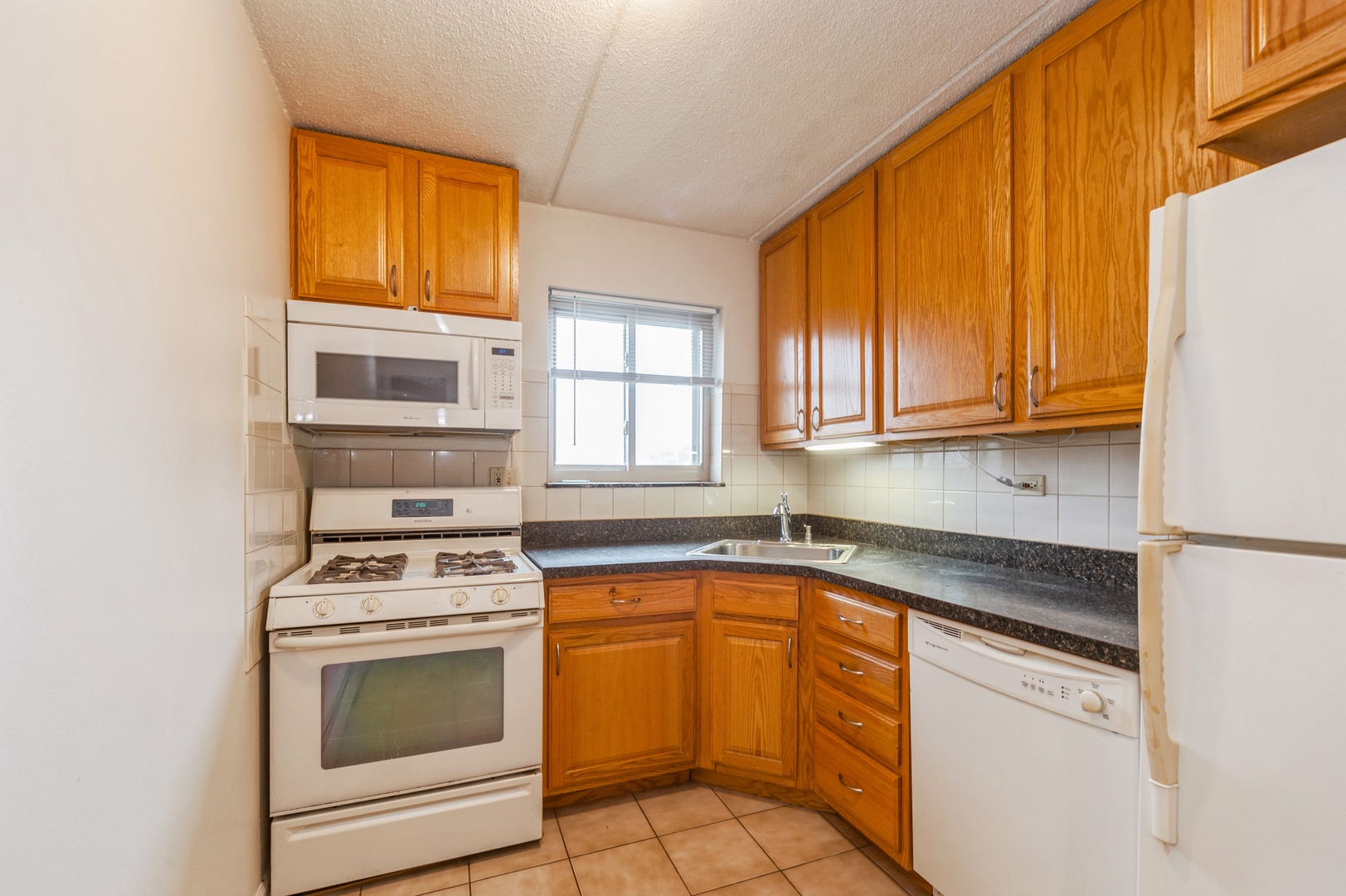 577 Fairway View Drive, Unit 2L Wheeling, IL 60090 - Photo 8 of 15 a kitchen with stainless steel appliances granite countertop a stove a sink and a microwave