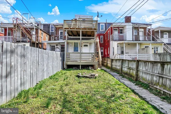 a view of a house with a small yard and wooden fence