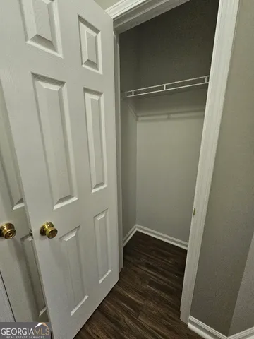 a view of a room with wooden floor and white walls