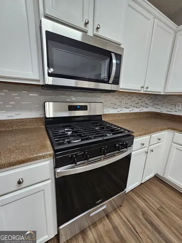 a stove top oven sitting inside of a kitchen
