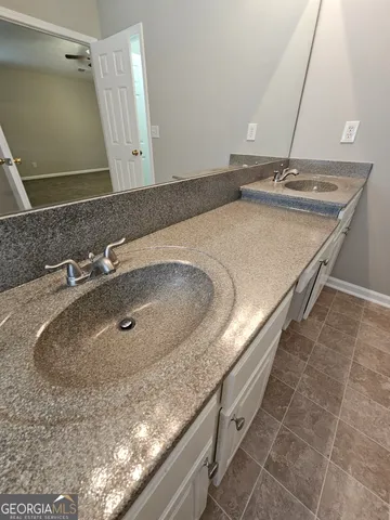 a bathroom with a granite countertop sink a mirror and shower