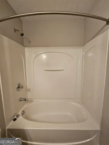 a bathroom with a shower and a bath tub