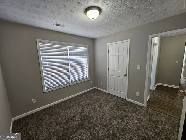 an empty room with closet and windows