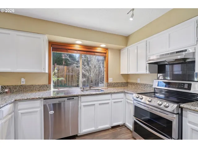 a kitchen with stainless steel appliances granite countertop a stove and a sink