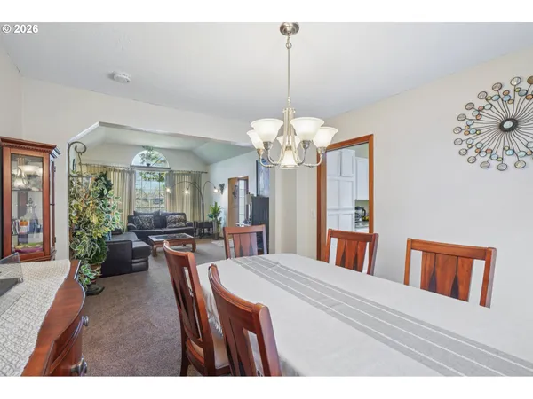a view of a dining room with furniture a chandelier and wooden floor