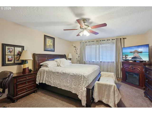 a bedroom with a bed dresser and a flat screen tv