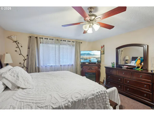 a bedroom with a bed and a dresser with mirror