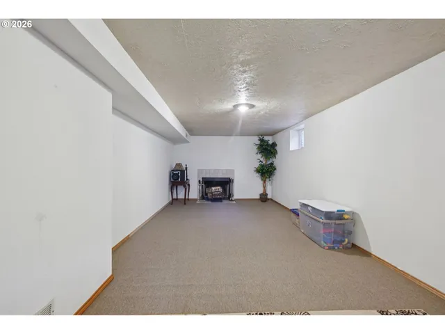 a view of empty room with fireplace and fan