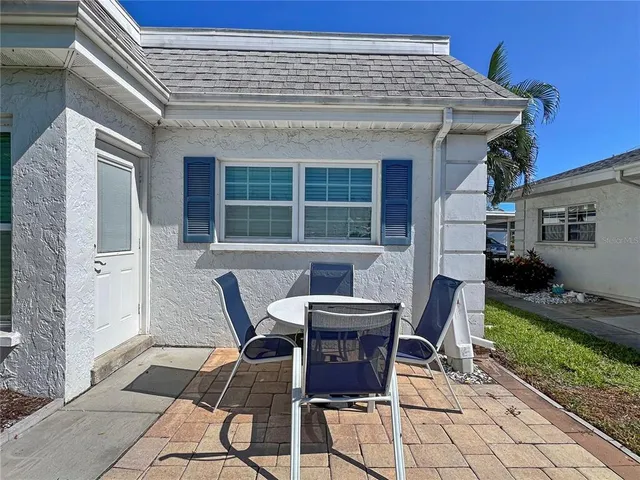 a view of a patio with table and chairs and wooden fence